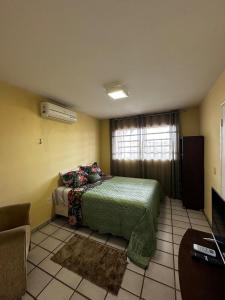 ein Schlafzimmer mit einem Bett und einem Fenster in der Unterkunft Casa agradável e muito ampla em Campina Grande in Campina Grande