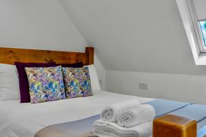 Edinburgh's Winter Chalet في روزلين: غرفة نوم بها سرير مع مناشف عليه +20 صورة