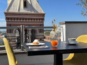 a black table with two plates of food on a balcony at La Griffe Hotel Roma in Rome