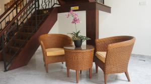 a table with two chairs and a potted plant on it at Heeren Straits Hotel in Malacca