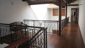 a staircase in a house with wooden floors and white walls at Heeren Straits Hotel in Malacca