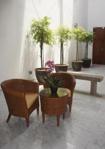 a group of chairs and potted plants in a room at Heeren Straits Hotel in Malacca