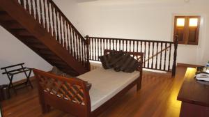 a room with a staircase with a bench and a stair case at Heeren Straits Hotel in Malacca
