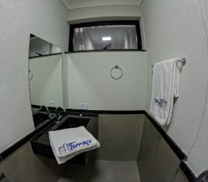 a small bathroom with a sink and a mirror at Terraço Plaza Hotel in Jabuticabal