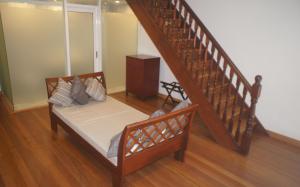 a bedroom with a bed and a stair case at Heeren Straits Hotel in Malacca