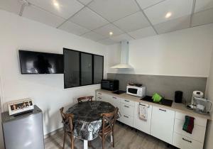 een keuken met een tafel met stoelen en een magnetron bij La Fontaine in Neussargues en Pinatelle