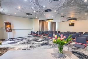 a conference room with chairs and a vase of flowers at ibis Bucharest Politehnica in Bucharest