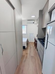 a kitchen with white cabinets and a refrigerator at Studio SUPER LUXO a 5 min do Nubank Parque in São Paulo