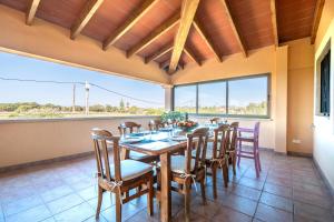 a dining room with a table and chairs and a large window at Can Jeroni Petit in Cala Ferrera