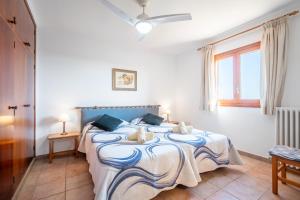 a bedroom with a blue and white bed with a window at Can Jeroni Petit in Cala Ferrera +23 photos