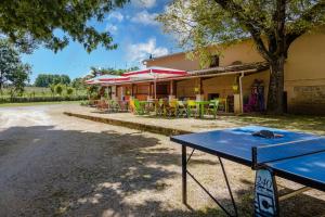una mesa de ping pong frente a un edificio en Tente Lodge 8 personnes, en Saint-Martial-de-Nabirat