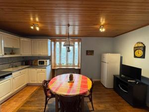 a kitchen with a table and a kitchen with a refrigerator at Le Dock De La Pointe in Tréffiagat