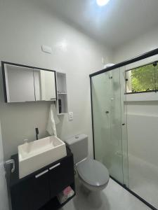 a bathroom with a toilet and a sink and a shower at Sobrado moderno in Blumenau