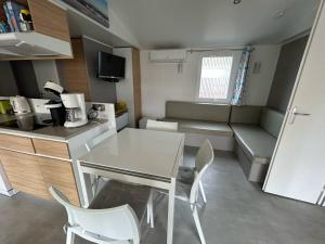 a small kitchen with a table and chairs in a room at Mobilhome sur camping 4 étoiles in Le Teich