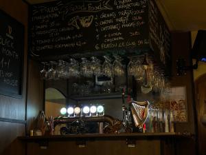 a bar with many glasses on a wall with a shelf at LeClub in Târgu-Mureş +3 photos