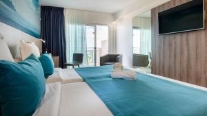 a hotel room with a large bed with blue pillows at Labranda Marieta & Spa - Adults Only in Playa del Ingles