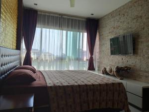a bedroom with a bed and a large window at The Gallery Condominium B in Jomtien Beach