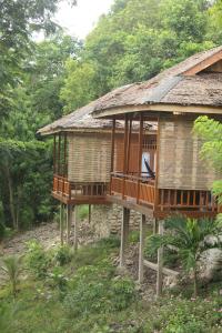 a house with balconies on the side of it at Malenge Dive Resort in Pulau Malenge