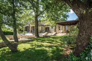 a yard with trees and a house at Villa Rovere Orbani in Orbani