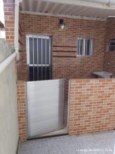 a brick wall with a gate in front of a building at Casa Pedra in Pedra de Guaratiba