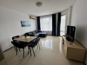 a living room with a table and a couch and a television at MIRA Apartment SEA PARADISE in Kavarna