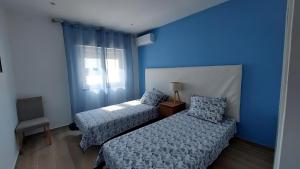 a bedroom with two beds and a blue wall at Villa in Salgados Golf - Albufeira in Guia +17 photos