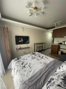 Un dormitorio con una cama y un ventilador de techo. en Cayden Staycation, en Lapu Lapu City