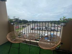 2 sillas y una mesa en un balcón con aparcamiento en Cayden Staycation, en Lapu Lapu City