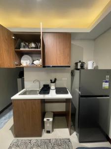 Una pequeña cocina con fregadero y refrigerador. en Cayden Staycation, en Lapu Lapu City