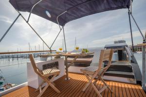 eine Terrasse mit einem Tisch und Stühlen auf einem Boot in der Unterkunft Exclusivas vistas al mar en casa barco, pleno centro, terraza, parking in A Coruña