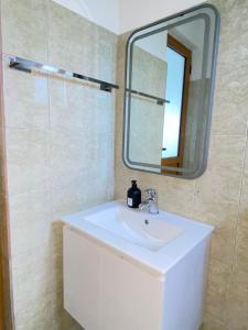 a bathroom with a white sink and a mirror at APARTAMENT RADHIME in Vlorë +37 photos
