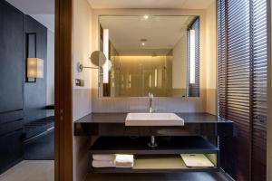 a bathroom with a sink and a large mirror at Amara Bangkok Hotel in Bangkok