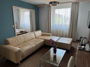 salon z kanapą i szklanym stołem w obiekcie Hotel Famulus w Győr