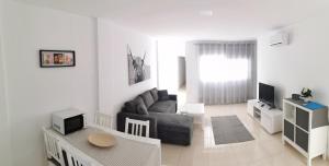 una sala de estar con un sofá y una mesa en Residencial Amber III - Apartamento nuevo, amplio y cómodo, en Vecindario