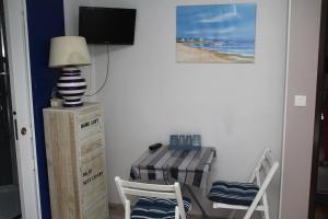 a dining room with a table and a television at Studio Mer à Mastaing in Mastaing