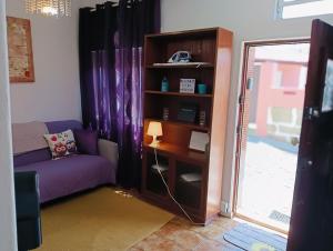 a living room with a purple couch and a book shelf at Simple but cosyBest locations in Vila Nova de Gaia