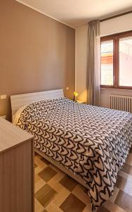 a bedroom with a bed with a black and white comforter at Anna & Maio Apartments in Camerano
