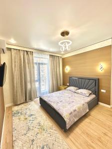une chambre avec un grand lit et un lustre dans l'établissement Buta Fenomen, à Almaty
