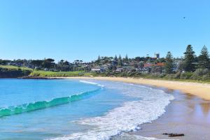 a beach with the ocean and buildings in the background at Bermagui Motor Inn in Bermagui