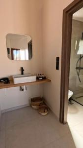 a bathroom with a sink and a mirror on the wall at Dris Suites in Nikiana +21 photos