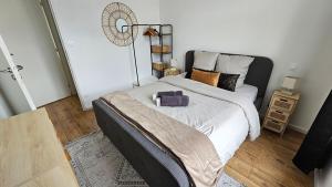 a bedroom with a large bed and a fan at Elegant apartment in a luxury residence in Arras