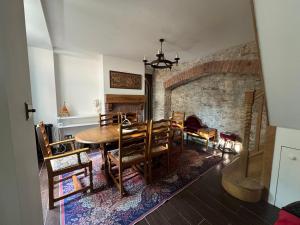 a dining room with a table and a stone fireplace at Seven Sisters in Glastonbury