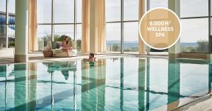 kobieta siedząca na krześle obok basenu w obiekcie Falkensteiner Hotel & Spa Iadera w mieście Zadar