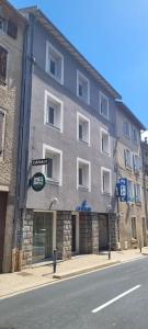 a large building on the side of a street at Logis Hotel Restaurant Le Cygne in Yssingeaux