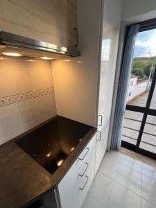 una cucina con piano di lavoro e finestra di Apartman Foz Lagoon a Foz do Arelho