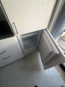 una cucina con mobili bianchi e pavimento piastrellato di Apartman Foz Lagoon a Foz do Arelho