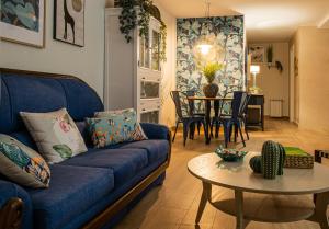 a living room with a blue couch and a table at Amazonia in Coslada