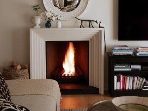 a fireplace with a fire in it in a living room at Villa Coste Simon's Town in Simonʼs Town