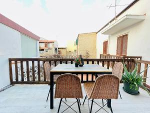 a wooden table and chairs on a balcony at Appartamento fronte mare nel cuore di Stintino in Stintino