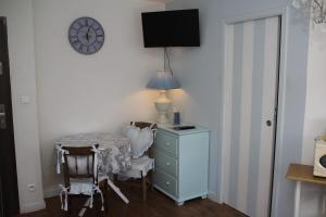 a room with a table and a desk and a clock at Studio romantique à la campagne à Mastaing in Mastaing
